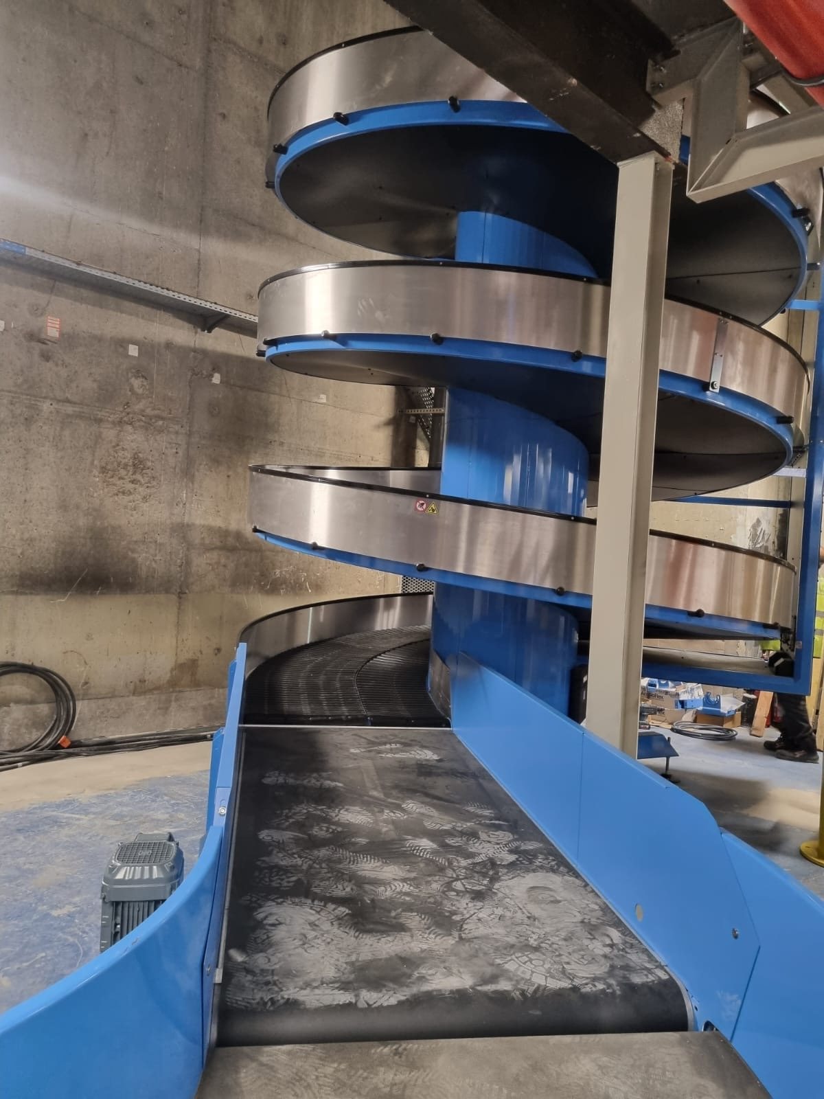TP Metal d.o.o. — spiral baggage handling conveyor installation at Paris-Orly Airport, delivered with the Daifuku Logan team